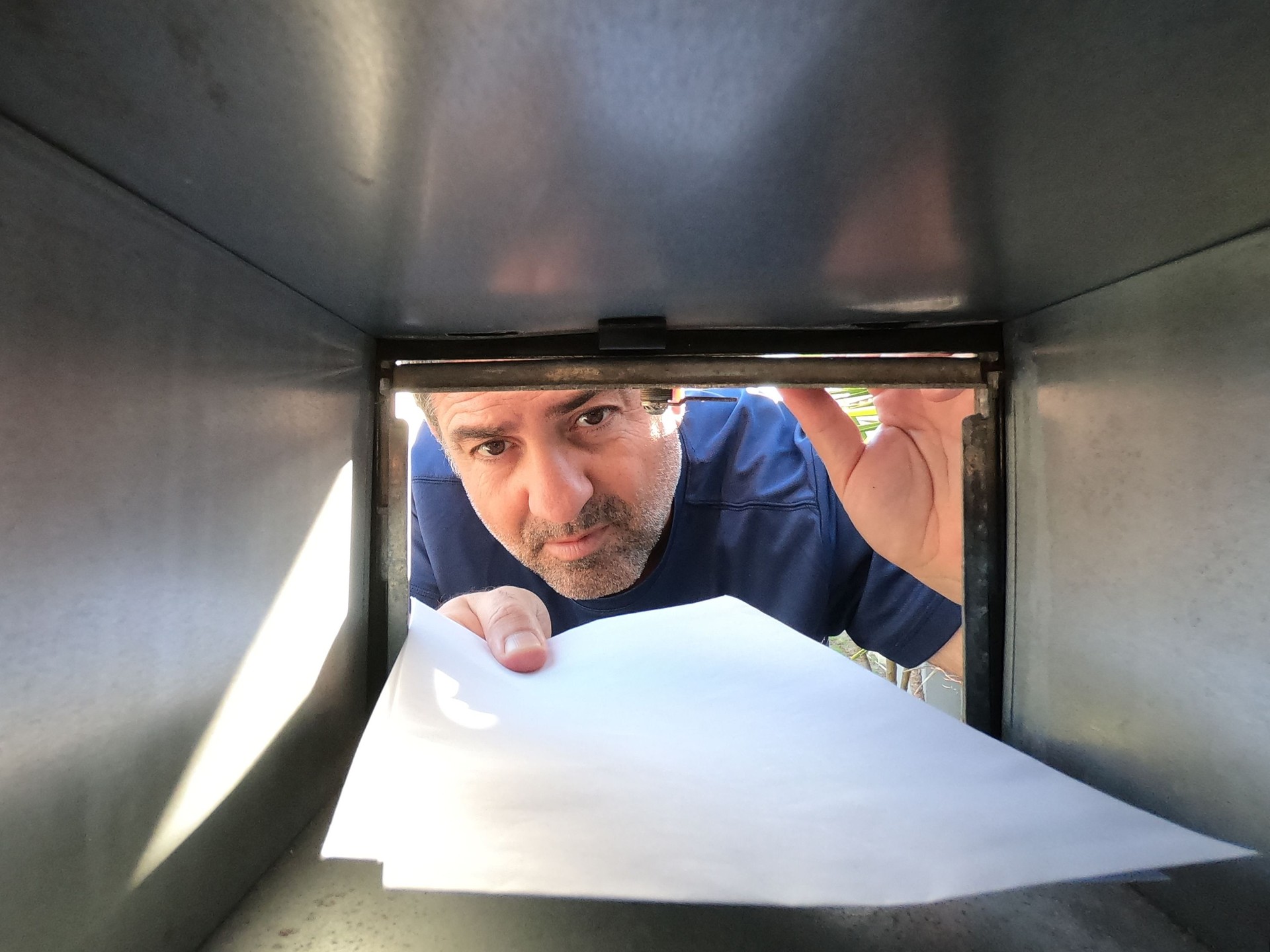 Man sending or collecting mail from a postal box